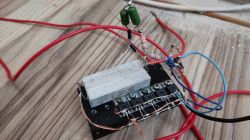 Układ elektroniczny z elementami obniżającymi napięcie, w tym kondensatory i rezystory, na drewnianym stole.