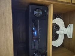 Amplituner Pionier ustawiony na STEREO w drewnianej szafce, obok rzeźby anioła.