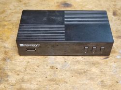 Dekoder telewizji Opticum Blue R265 Lite na drewnianym tle.
