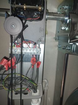 Panel sterowania z przewodami i połączeniami do automatyki bramy przemysłowej.
