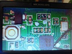 Close-up of a circuit board with electronic components under magnification.