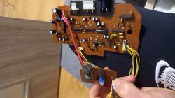 Wyjęta płytka drukowana ze wzmacniacza subwoofera z elementami elektronicznymi i kablami.