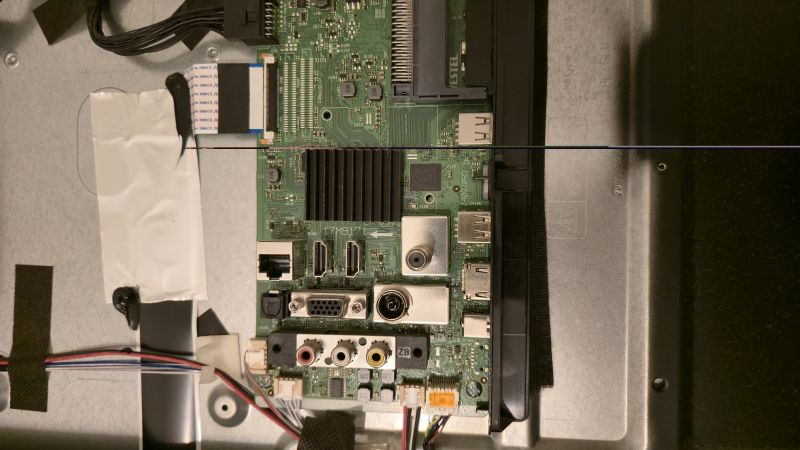 Płyta główna telewizora z portami HDMI, VGA, USB i gniazdami antenowymi na metalowej obudowie