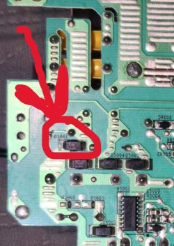 Zbliżenie na płytkę PCB z zaznaczoną uszkodzoną diodą prostowniczą SMD