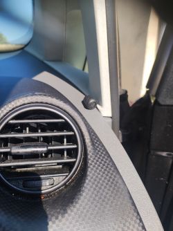 Wnętrze samochodu z widocznym kratką wentylacyjną na desce rozdzielczej.