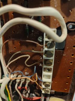 Płyta drukowana z przewodami i elementami elektronicznymi w starym domofonie.