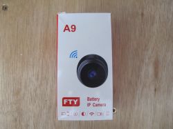 FTY A9 IP Camera Packaging Packaging of an FTY A9 battery IP camera on a wooden surface.