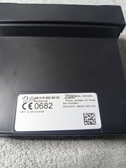Black electronic component with a label containing identification and technical information.