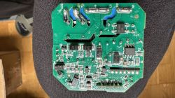 Image of a green electronic circuit board with various components like capacitors and resistors.