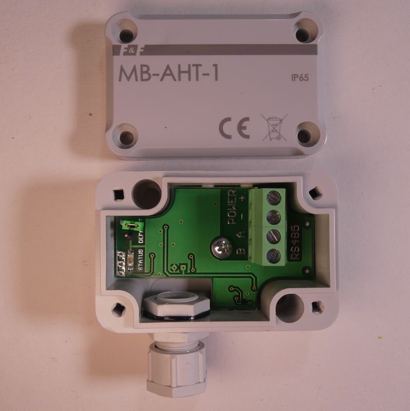 Otwarta obudowa czujnika MB-AHT-1 z widoczną płytką elektroniczną i zaciskami śrubowymi.