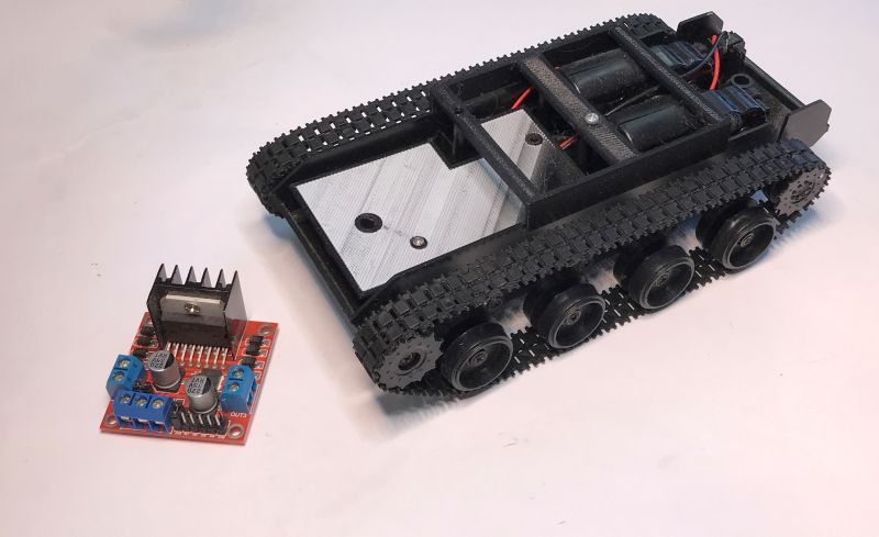 Model robota z gąsienicami obok modułu L298.