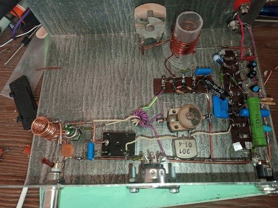 Wnętrze metalowej obudowy z ręcznie montowanym układem transceivera i cewkami z drutu miedzianego