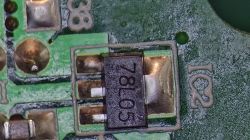 Zbliżenie na stabilizator napięcia 78105 w obudowie SMD, zamontowany na zielonej płytce PCB, oznaczenie IC2.