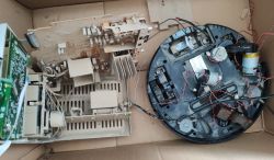 Toy tank chassis and electronic components in a cardboard box.