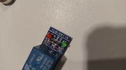 Moduł przekaźnika elektronicznego z dwoma diodami LED (czerwona i zielona) na niebieskiej płytce oznaczonej YLM-D9119.