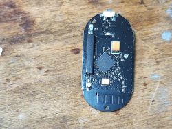 Inside of Sonoff SNZB-04 Sensor with CC2530 Chip Sonoff SNZB-04 sensor PCB with visible CC2530 chip on a wooden surface.