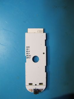 View of the bottom part of a white PCB with labels G, V, SWS, and RST and a central hole.