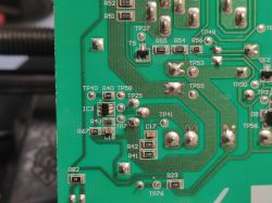 Close-up of a printed circuit board with various component designations and test points.