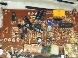 Widok płytki drukowanej radia z różnymi elementami elektronicznymi, takimi jak rezystory, kondensatory i cewki.