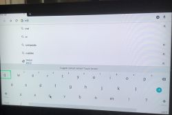 Ekran telewizora z przeglądarką internetową i klawiaturą ekranową podczas wpisywania frazy „onet”.