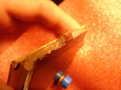 Close-up of a PCB edge with applied glue or silicone.
