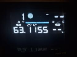 Ekran urządzenia pokazujący temperaturę 1°C, wilgotność 63% i godzinę 11:55