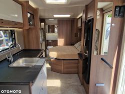 Interior of a luxury camper with visible kitchen and bed.