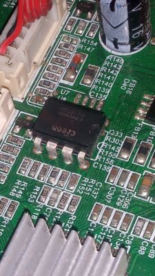 Integrated Circuit on I-joy i-led19 hk7050d-v4.3c TV Mainboard Close-up of an integrated circuit on a green TV motherboard with labeled electronic components.