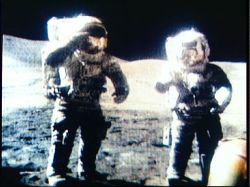Dwóch astronautów w skafandrach kosmicznych stoi na powierzchni Księżyca