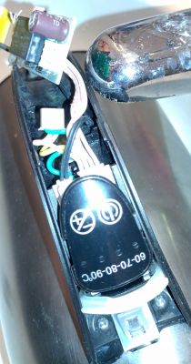 Close-up of electric kettle components showing wires and a circuit board with electronic elements.