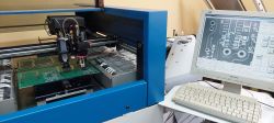 Automat montażowy M60 z panelem operatorskim i płytką PCB w trakcie pracy.