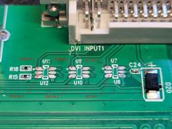 Zbliżenie na płytkę elektroniczną z oznaczeniami DVI INPUT1 i opisanymi punktami połączeń.