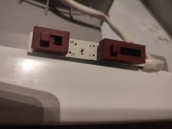 Zbliżenie na biały przewód z brązowymi złączami i oznaczeniami elektrycznymi