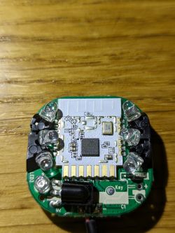 Electronic circuit board with several LEDs on a wooden surface.