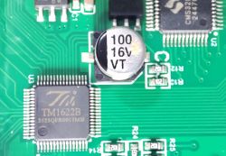 Close-up of a PCB with a 16V capacitor and TM1622B and CMS32 microchips visible