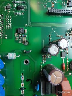 Zdjęcie układu przetwornicy DC-DC na płytce PCB z kondensatorami i innymi elementami.