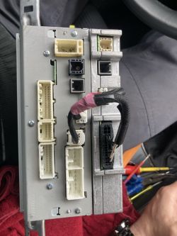 Tył fabrycznego radia z licznymi złączami i wtyczkami