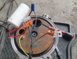 Zbliżenie na połączenia elektryczne w urządzeniu, z widocznymi kolorowymi przewodami i złączkami.