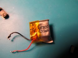 Damaged Battery on a Blue Background Damaged battery with two wires on a blue background