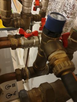 Zbliżenie na instalację hydrauliczną z zaworami i rurami.