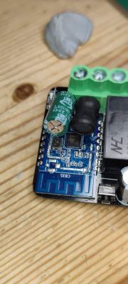 Electronic circuit board with components on a wooden surface.