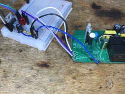 Sonoff Dual R2 with Connections on a Breadboard Close-up of Sonoff Dual R2 PCB with connected wires on a breadboard.