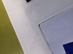 Close-up of alignment jig corner with trimmed paper fitted into the frame