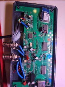 Photo of the inside of an electronic device with visible circuit board and wires.