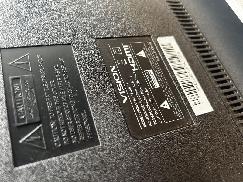 Close-up of a Vision TV back panel with the specification label and a barcode.