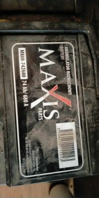 Zbliżenie na akumulator marki Maxis z etykietą zawierającą kod kreskowy i oznaczenia techniczne.