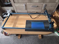 Zestaw Sculpfun S9 na drewnianym stole, z poszerzającym pole robocze rozszerzeniem i akcesoriami do nadmuchu powietrza.