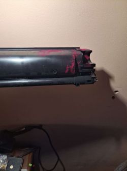 Zbliżenie na toner w drukarce Kyocera FS-C2126MFP+ z widocznymi śladami czerwonego tuszu.
