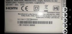 Etikett mit technischen Informationen über ein elektronisches Gerät, einschließlich Angaben zur Stromversorgung und Dolby-Lizenz.