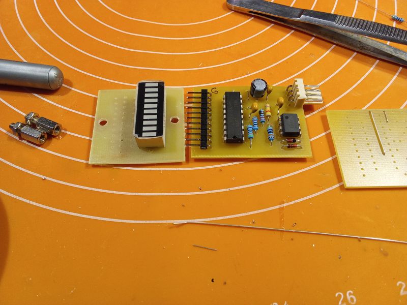 Close-up of electronic components on an orange cutting mat.